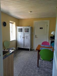 una cucina con tavolo, sedie e armadio di Bed & Kitchen „Den gamle Skole“ Nr. Sejerslev a Højer