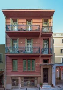 un edificio rojo con balcones encima en Apollonas Luxurious Apartments en Atenas