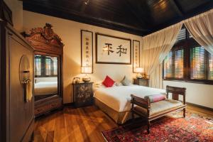 a bedroom with a bed and a chair and windows at Campbell House in George Town