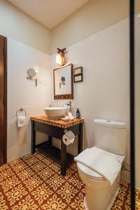 a bathroom with a white toilet and a sink at Campbell House in George Town