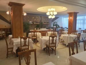 カステル・サン・ジョヴァンニにあるHotel Motel 2の白いテーブルと椅子、シャンデリアのあるレストラン