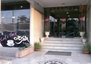 uma frente de loja com uma placa na frente de um edifício em Al Farhan Hotel Suites (Exit 15) em Riyadh