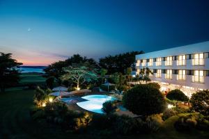un edificio con piscina por la noche en The Atlantic Hotel - Small Luxury Hotels of the World, en St Brelade