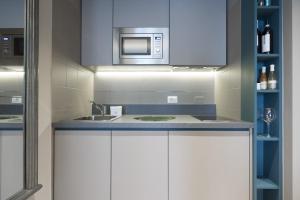 Una cocina con gabinetes blancos y un microondas. en Contempora Apartments - Elvezia 8 - E14, en Milán