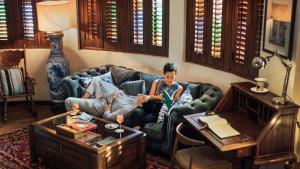 a woman sitting on a couch in a living room at Campbell House in George Town