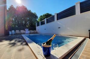 a bottle of champagne in a bucket next to a swimming pool at Villa with a heated Pool near Split with Magnificent View in Solin