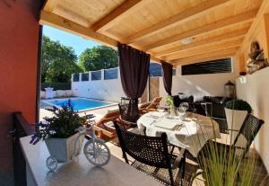 une terrasse avec une table et des chaises ainsi qu'une piscine dans l'établissement Villa with a heated Pool near Split with Magnificent View, à Solin