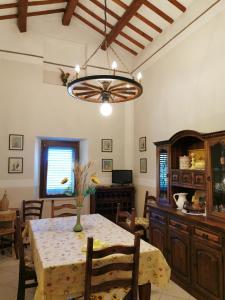 comedor con mesa y lámpara de araña en Casale Fonte delle Pietre, en Offida