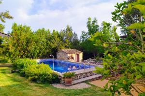 a swimming pool in a garden with a house at Ca na Maria in Manacor