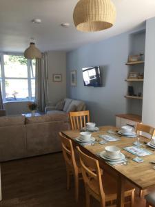 a dining room and living room with a table and chairs at Eddies by the Sea in Ilfracombe