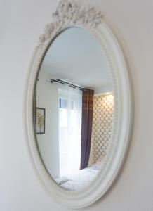 um espelho numa parede com uma cama num quarto em Hotel Europe BLV em Paris