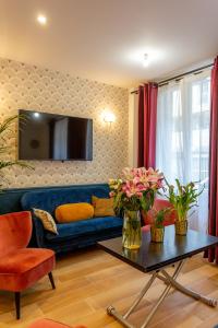 uma sala de estar com um sofá azul e uma mesa em Hotel Europe BLV em Paris