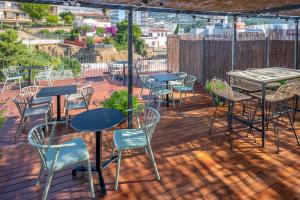 a patio with tables and chairs on a deck at GHT Miratge - Only Adults 18 and up in Lloret de Mar