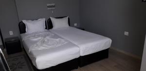 1 dormitorio con 1 cama grande con sábanas y almohadas blancas en Guest Rooms Tivona, en Pazardzhik