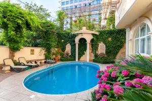 a swimming pool in a yard with flowers at Hotel Grace Nairi in Sochi