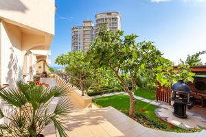 a house with a garden and a building at Hotel Grace Nairi in Sochi