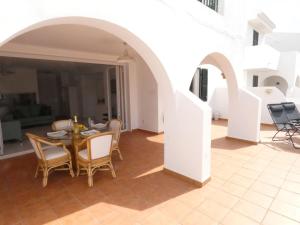 Apartamento Albatros-Son Parc Menorca في سون بارك: غرفة طعام مع طاولة وكراسي وممشى