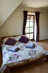 a bedroom with a bed with a floral bedspread and a window at Quo Vadis Lounge Bed & Breakfast in Kazimierz Dolny