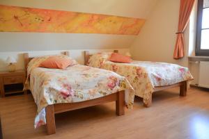 a bedroom with two beds and a painting on the wall at Quo Vadis Lounge Bed & Breakfast in Kazimierz Dolny