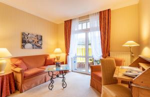 a living room with a couch and a table at Strandhotel Sylt Westerland in Westerland