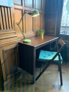 a desk with a green lamp and a chair at Zentric Hostel in León