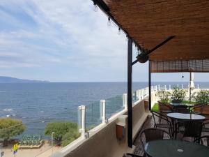 a balcony with tables and chairs and the ocean at Rallye Hotel in L'Escala