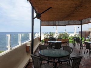 a patio with tables and chairs and the ocean at Rallye Hotel in L'Escala