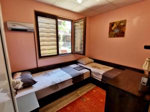 duas camas num quarto com duas janelas em Guest House Kosharite em Byala Ruse