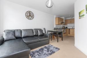 a living room with a leather couch and a table at Cosy One Bedroom Apartment in Worcester