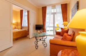 a hotel room with a bed and a couch and a table at Strandhotel Sylt Westerland in Westerland