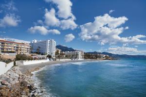 a view of a beach with buildings and the ocean at Hotel Riu Monica - Adults Only in Nerja