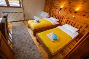 a room with two beds in a wooden cabin at Apartments Tango in Kolašin