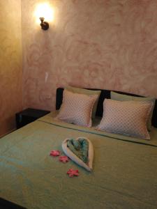 a bed with two towels and flowers on it at Nouveau Bungalow Djerba in Houmt Souk