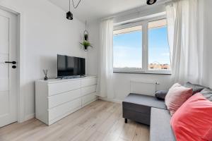 een woonkamer met een bank en een tv bij Apartamenty Świętej Barbary in Gdańsk