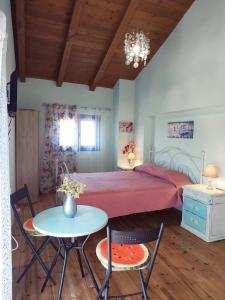 Schlafzimmer mit einem Bett, einem Tisch und Stühlen in der Unterkunft Maria GuestHouse in Aliveri