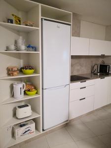 cocina con armarios blancos y nevera en Iacobus VUT-CO-00371O, en Padrón