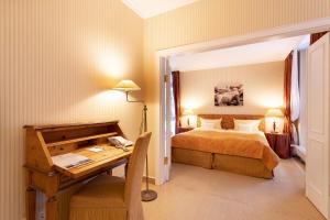 a bedroom with a bed and a desk with a desk at Strandhotel Sylt Westerland in Westerland