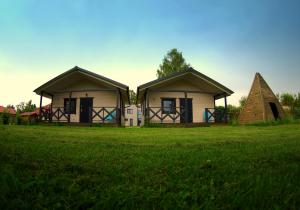 Deux petites maisons dans un champ d'herbe dans l'établissement Domki letniskowe Babie Doły, à Gdynia