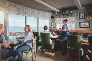een groep mensen aan een tafel in een restaurant bij Rock Point Inn in Lyme Regis