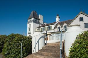 una gran casa blanca con una torre de reloj en Castle Penthouse, en Deganwy