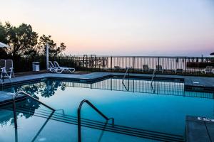 a swimming pool with a view of the ocean at River Hotel of Southport in Southport