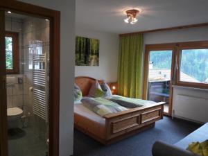 Schlafzimmer mit einem Bett, einer Dusche und einem Fenster in der Unterkunft Haus Lifinar - Carmen Juen in Sankt Gallenkirch