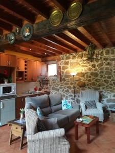 a living room with a couch and a stone wall at El Mirador del Gato I y II in Mesegar de Corneja +90 photos