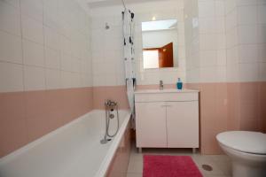 Un baño con bañera, inodoro y lavabo. en Casa Nau C, en Armação de Pêra