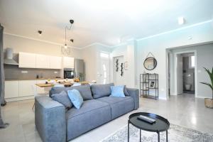 a living room with a blue couch and a kitchen at Tony's house with private pool, garden and parking in Zadar