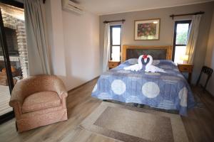 Un dormitorio con una cama con dos cisnes. en Resort 77, en Piriápolis