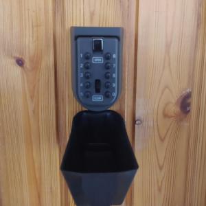 czarny telefon jest przymocowany do drewnianej ściany w obiekcie Krénusz Vendégház. w mieście Kaposvár