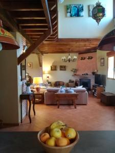 a living room with a bowl of fruit in the foreground at El Mirador del Gato I y II in Mesegar de Corneja