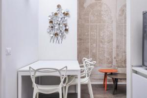 een eetkamer met een witte tafel en stoelen bij Contempora Apartments - Cavallotti 13 - B14 in Milaan