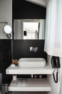 a bathroom with a white sink and a mirror at Hotel Boutique Castiglione del Lago in Castiglione del Lago